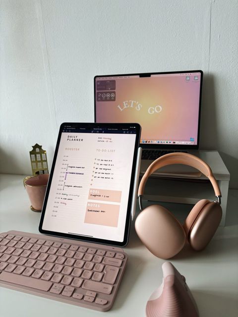 Bureau met tablet, roze toetsenbord en koptelefoon